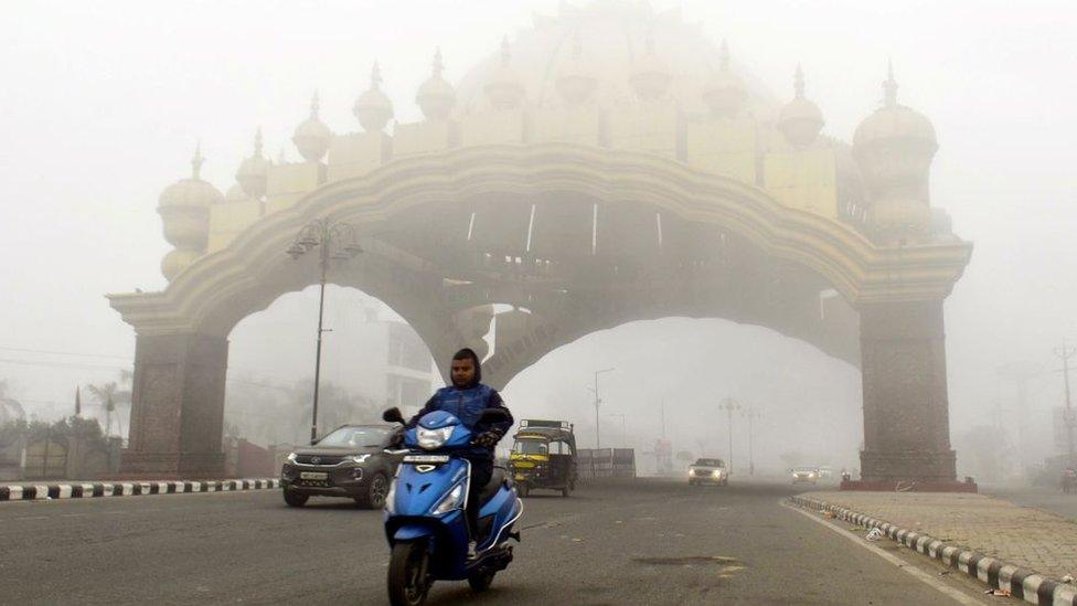 : Commuters are seen during a foggy winter day at Golden Gate, on January 3, 2022 in Amritsar, India. (Photo by Sameer Sehgal/Hindustan Times via Gett