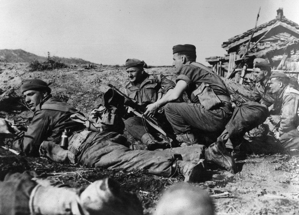 Men of the Argyll and Sutherland Highlanders take cover as they advance into the town of Chonju on the British front in North Korea during the Korean War