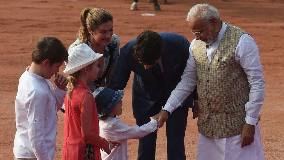 India's Prime Minister Narendra Modi (R) shakes hands with Hadrien Trudeau (C-bottom), the youngest son of Canada's Prime Minister Justin Trudeau (2nd R) and his wife Sophie Gregoire Trudeau (3rd L), as their other children Ella-Grace (2nd L) and Xavier (L) look on, while attending a ceremonial reception at the Presidential Palace in New Delhi on February 23, 2018.