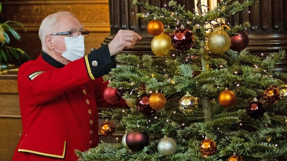 Edward Reid helps decorate a Christmas tree