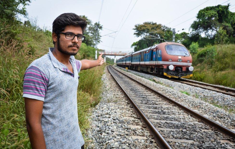 A local man points to the spot where three students were run over by a train while taking a selfie in Karnataka