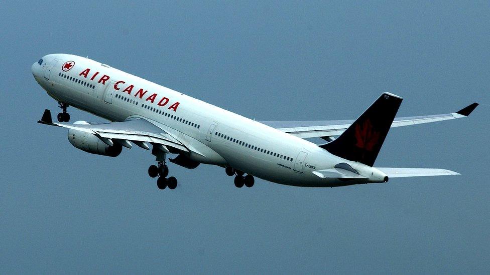 An Air Canada passenger plane is shown in flight at Heathrow Airport July 31, 2002 in London, England.