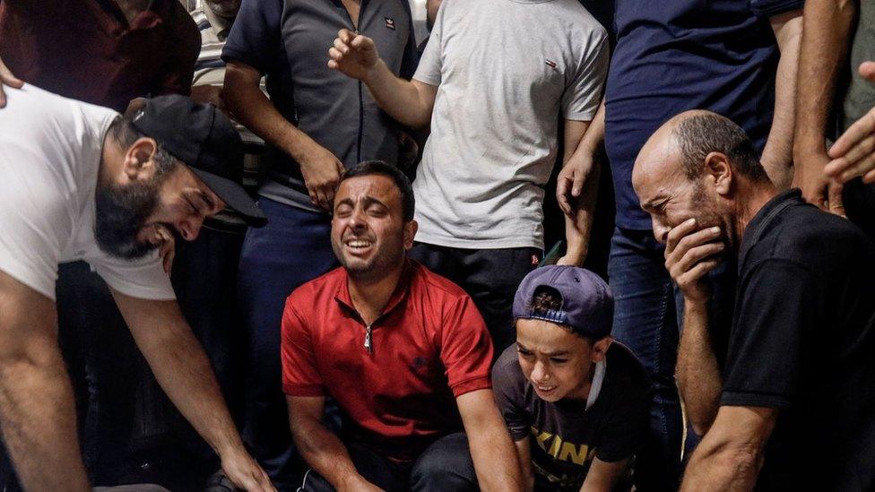 Family members and relatives mourn over the bodies of Palestinian militants killed in the latest infiltration operation into Israel, at the mortuary of a hospital in Gaza City on October 7, 2023.