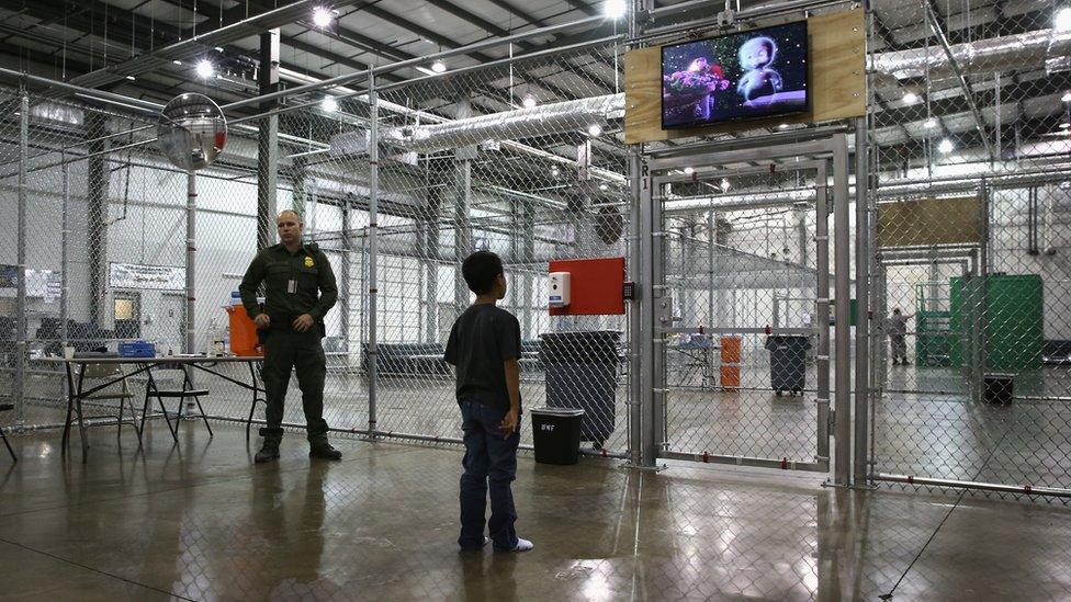 A child detainee watches a movie