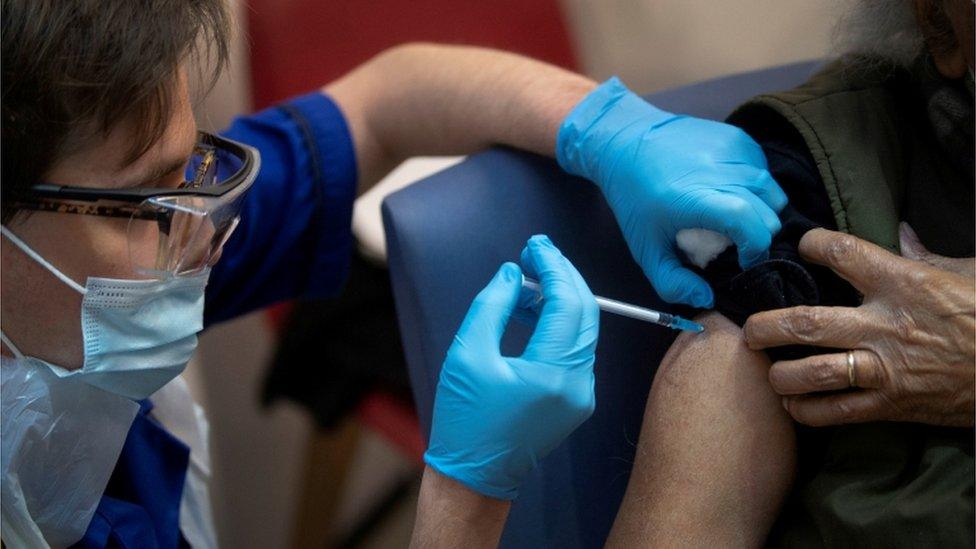 A man receives the first of two Pfizer/BioNTech COVID-19 vaccine jabs