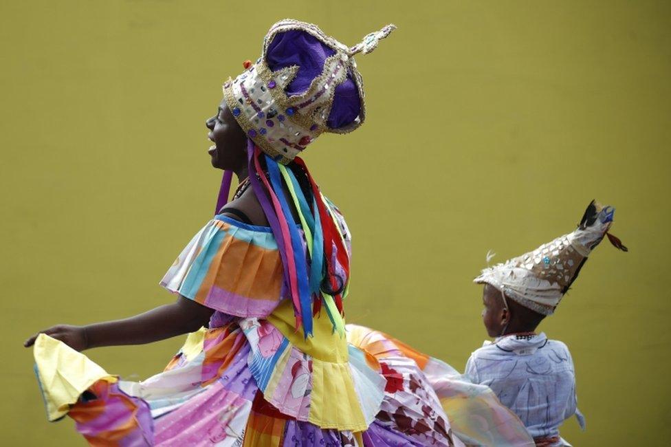 A woman and young boy hold hands and dance.