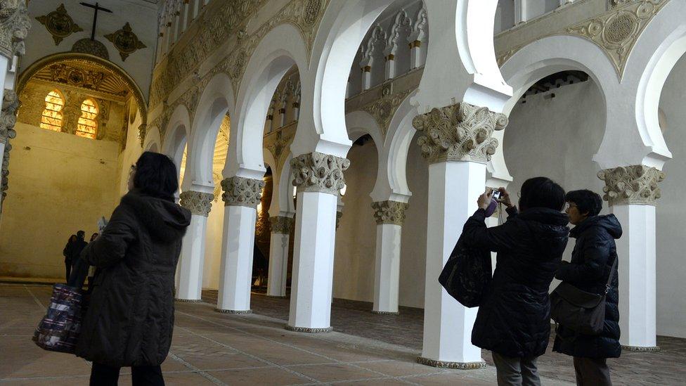 Tourists take pictures in the 12th Century synagogue of the Santa Maria La Blanca in Toledo