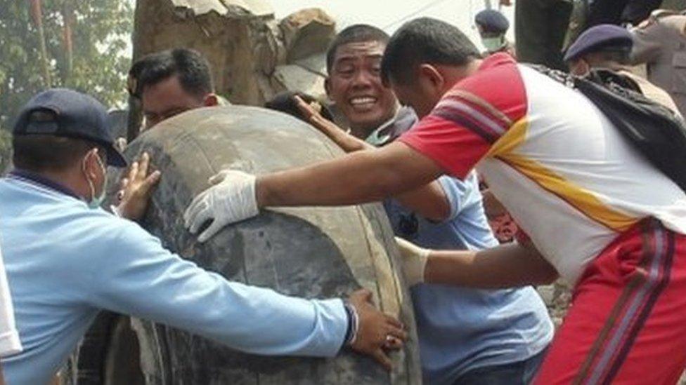 Military personnel remove an aircraft wheel at the site where an air force cargo plane crashed in Medan, Indonesia (30 June 2015)