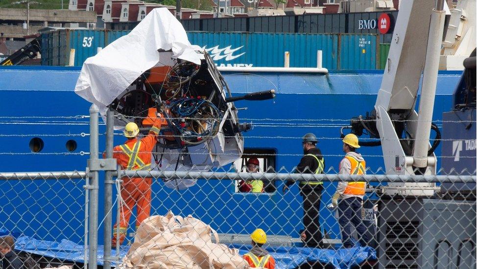 Debris from the Titan submersible, recovered from the ocean floor near the wreck of the Titanic, is unloaded