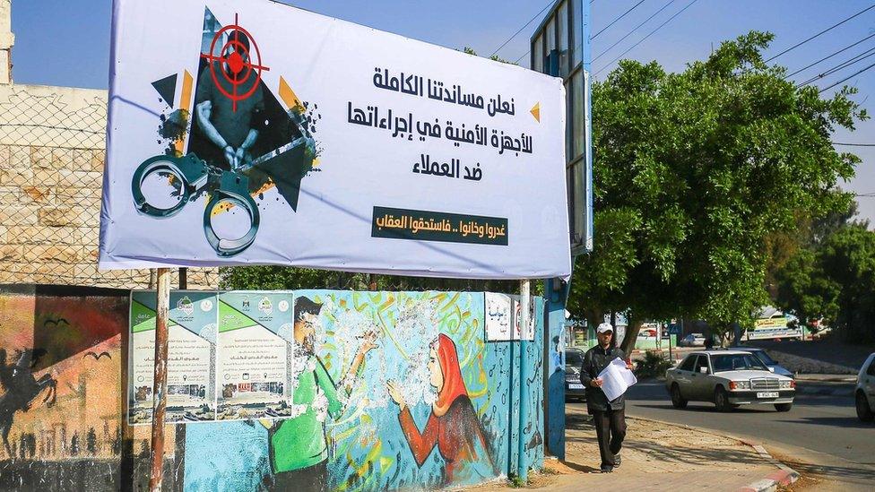 A man walks past a banner in Gaza City that says: "We declare our full support for the security authorities in their measures against collaborators" and "They betrayed, and backstabbed, and deserved the punishment" (5 April 2017)