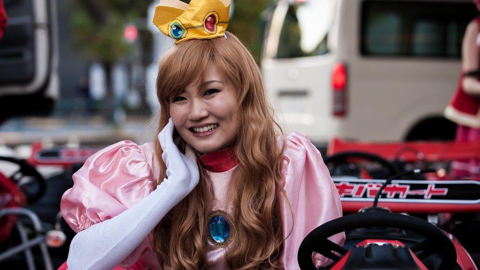 A woman in fancy dress in a motorised go-kart