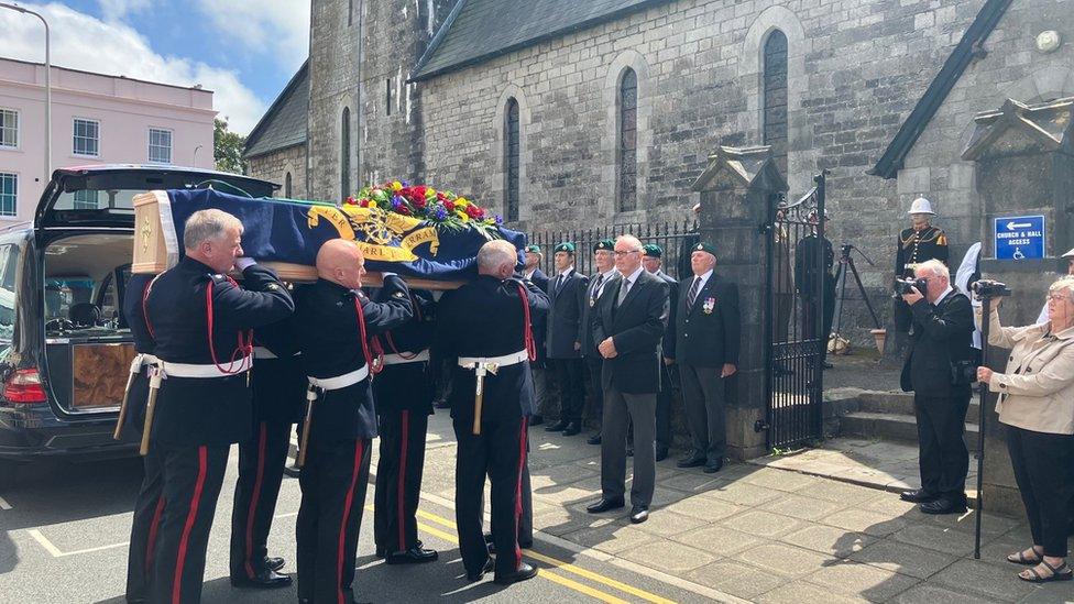 fire brigade carries the coffin into the church