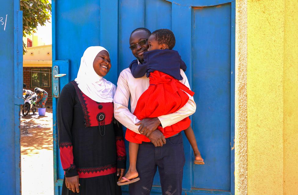 Family photo by the gate to the compound