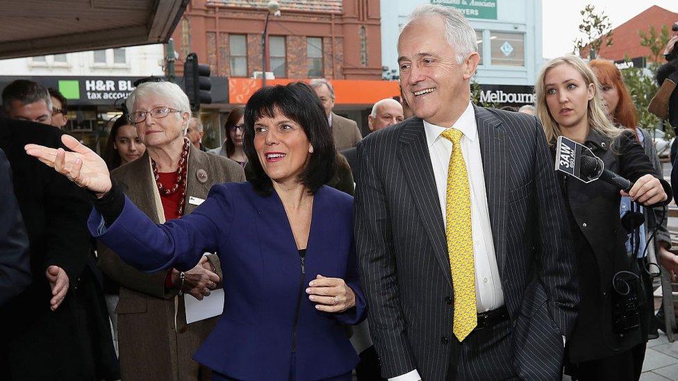 Julia Banks and Malcolm Turnbull walk and gesture in front of reporters