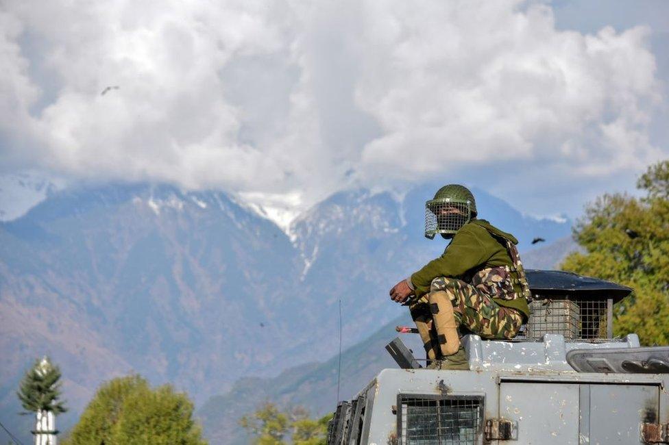 An Indian paramilitary trooper sits on the roof of the police vehicle during clashes in Srinagar in 2018.