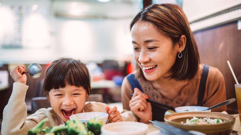 A mother and a child, eating at a restaurant