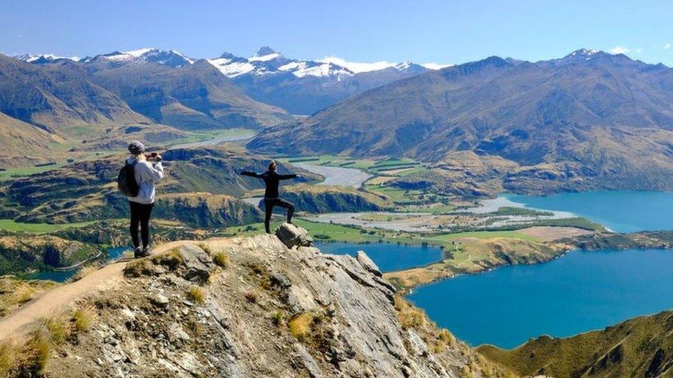 Tourists taking pictures of the views of Lake Wanaka from Roy's peak.