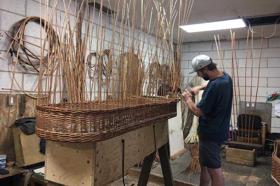 A wicker coffin under construction