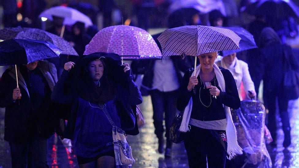 People walk through a rain shower