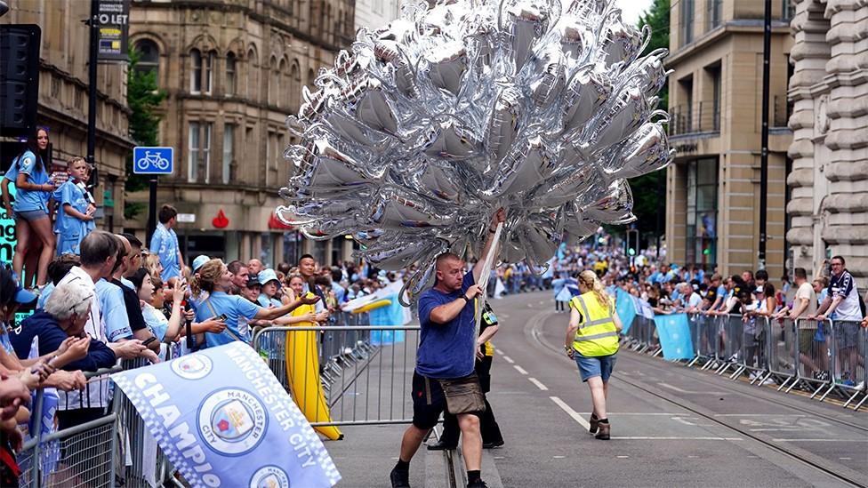 Man selling with trophy balloons