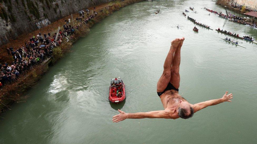 Marco Fois dives into the Tiber River from the Cavour bridge, as part of traditional New Year celebrations in Rome