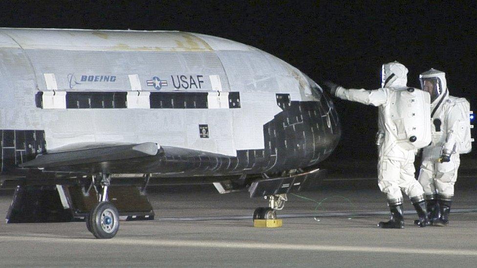 Technicians check the X-37B after its landing in 2010. The X-37B conducted experiments for more than 220 days during its maiden voyage.