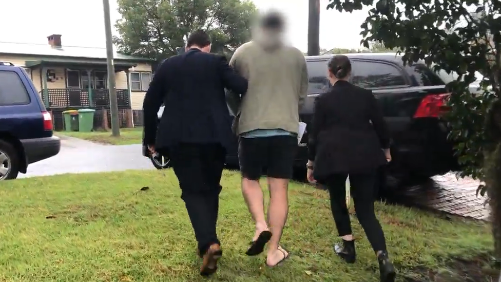 Detectives escorting the 30-year-old suspect in Wyong to police car