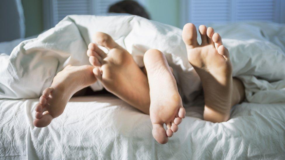 Couples feet in bed