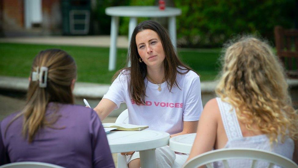 Natasha Eeles speaking to two girls at a workshop