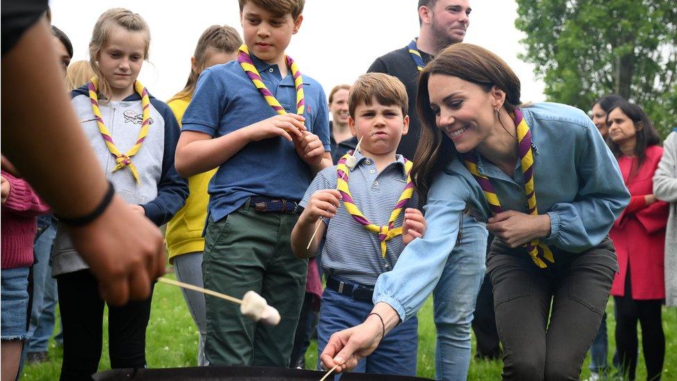 Prince George, Prince Louis and the Princess of Wales toast marshmallows as they join volunteers to help renovate and improve the 3rd Upton Scouts Hut in Slough, as part of the Big Help Out,