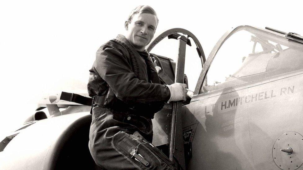 Henry Mitchell in black and white, climbing into a plane