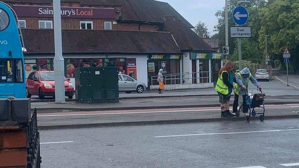 Jackie King helping a customer cross the road