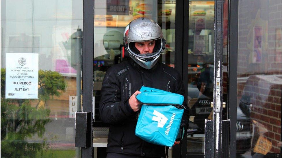 A Deliveroo driver collecting food from a re-opened Burger King restaurant in London