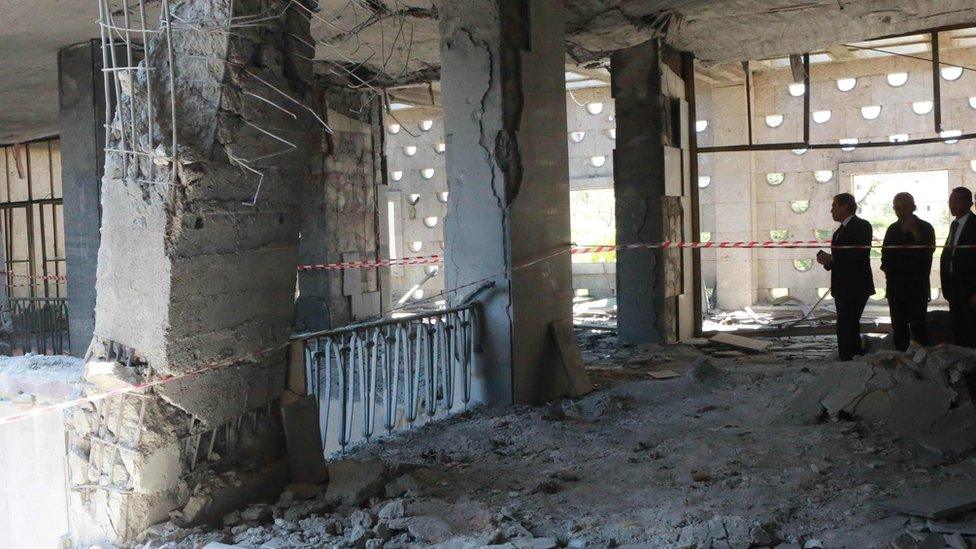 Men inspect damage after Turkey's parliament was bombed by rebel jets (16/07/2016)