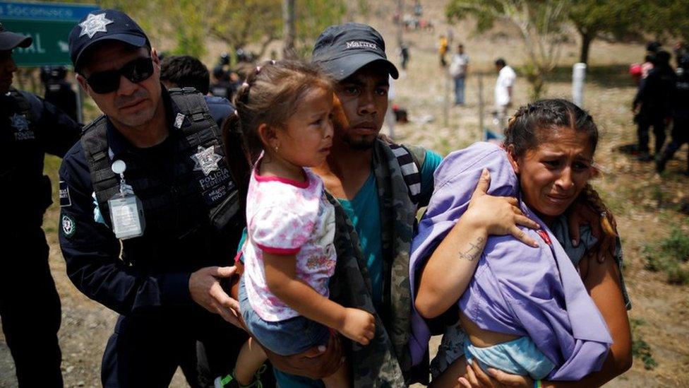 A family of Central American migrants is detained by Federal Police during a raid on their journey towards the United States