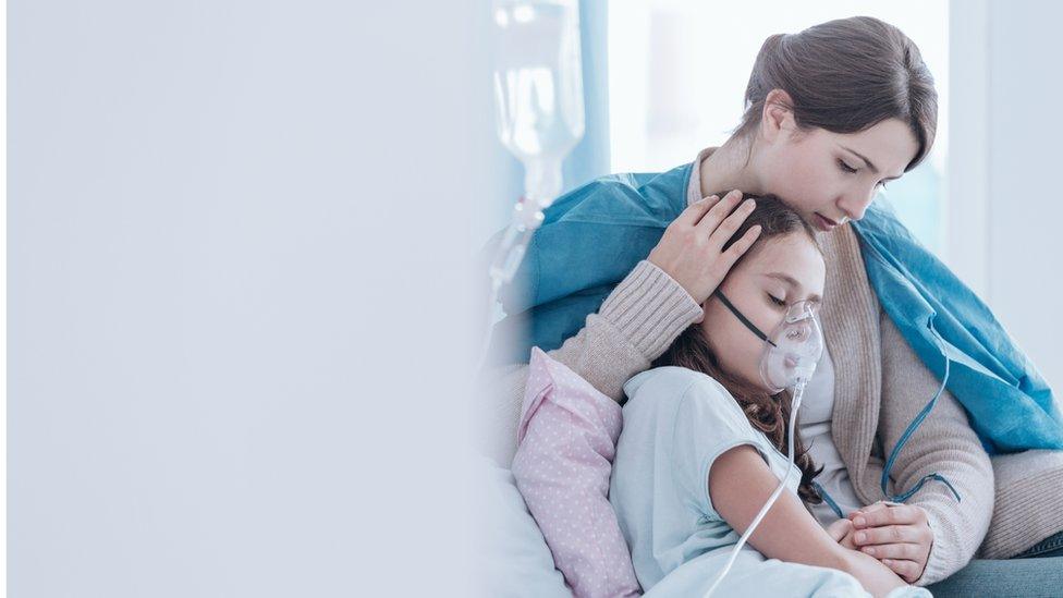 Older sister and child in the hospital breathing using an oxygen mask