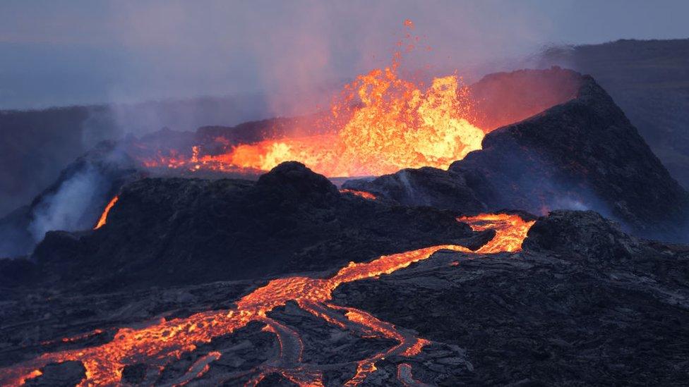 lava erupts from the top of the volcano