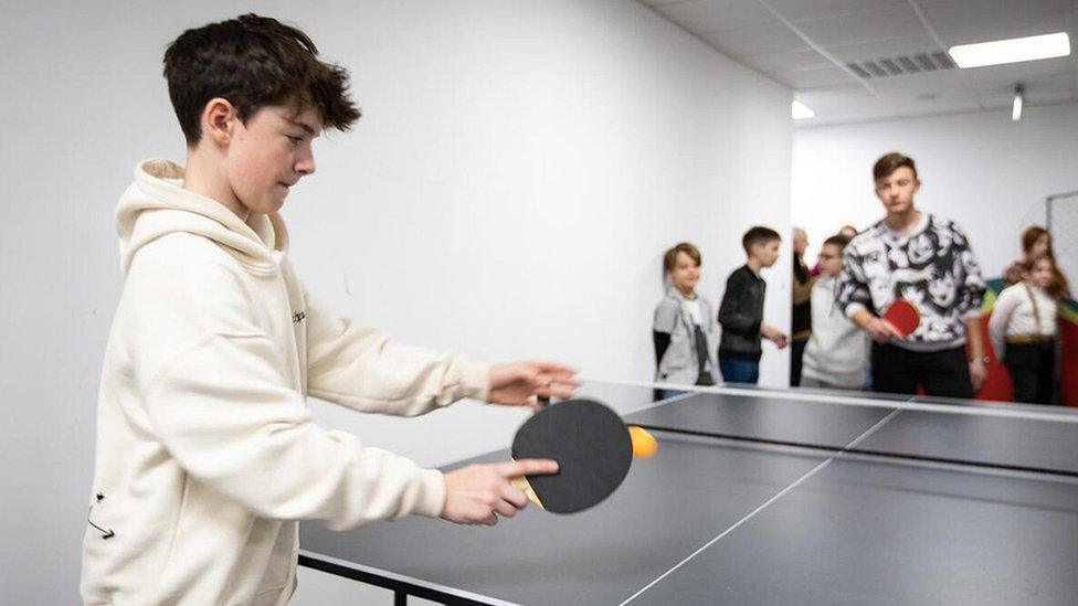 boy-playing-pingpong-with-children-at-a-school.