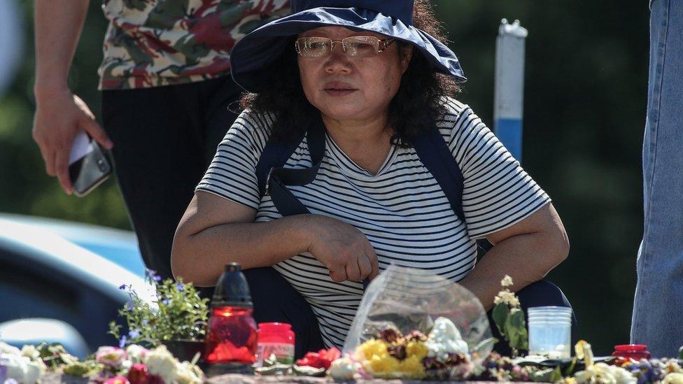 A woman looks at tributes on the banks of the river Danube