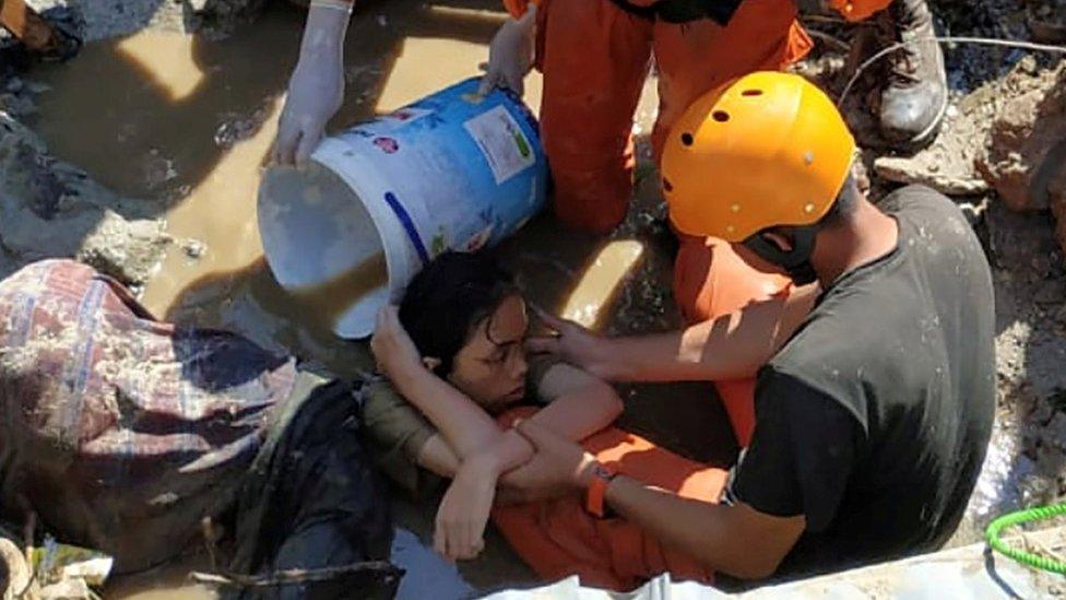 Search and rescue workers help rescue a person trapped in rubble in Palu, Central Sulawesi, Indonesia September 30, 2018