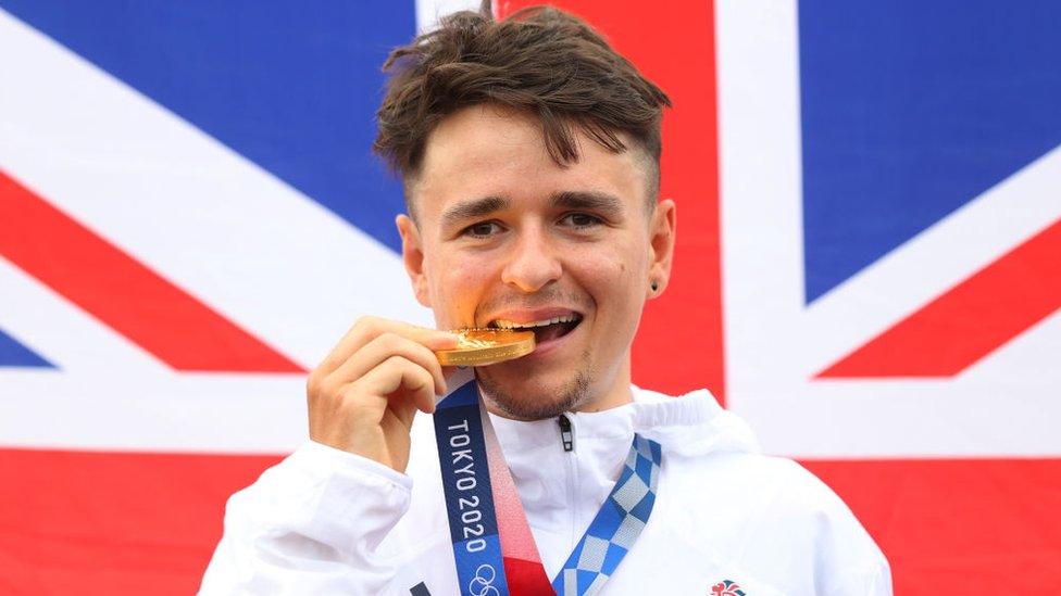 Thomas Pidcock of Team Great Britain bite his gold medal