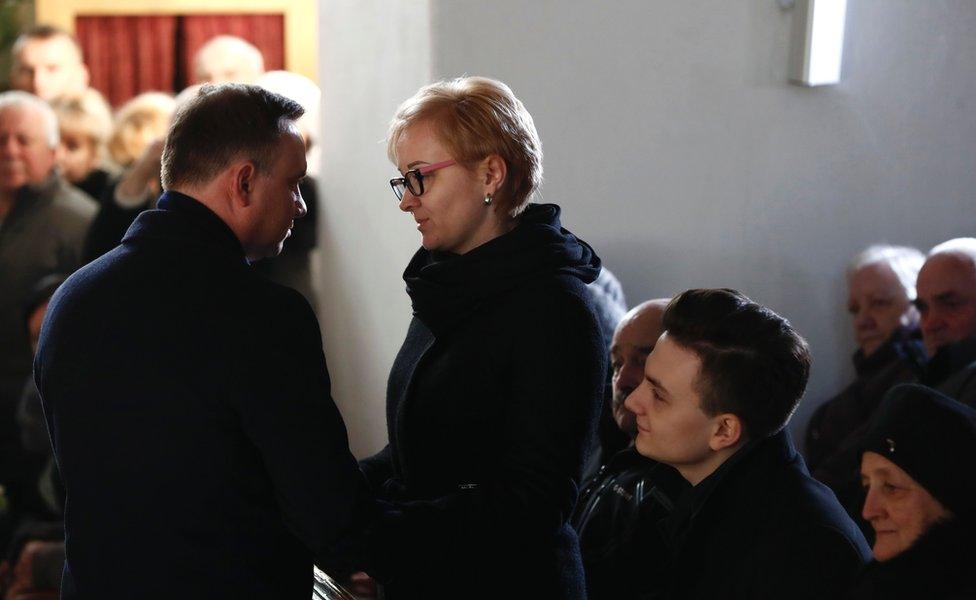 Polish President Andrzej Duda (L) presents condolences to the wife (C), son (2ndR) and mother (R) of Lukasz Urban, 30 December