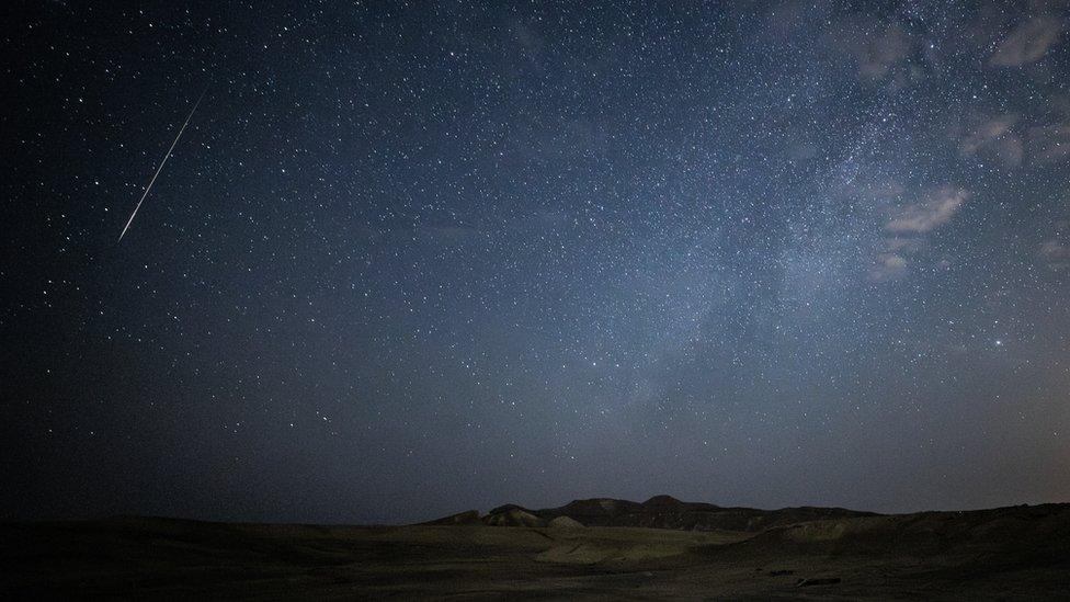 A meteor streaks across the night sky above Makhtesh Ramon area of Israelâs Negev Desert on August 13, 2023.