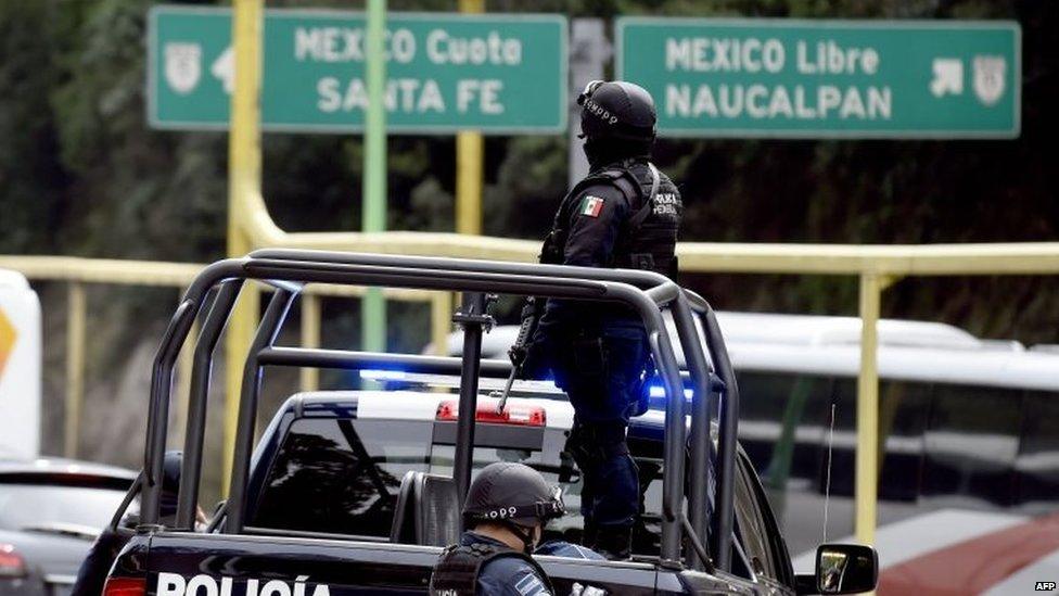 Police stand guard at a checkpoint on the road connecting Toluca with the Mexican capital on 14 July, 2015.