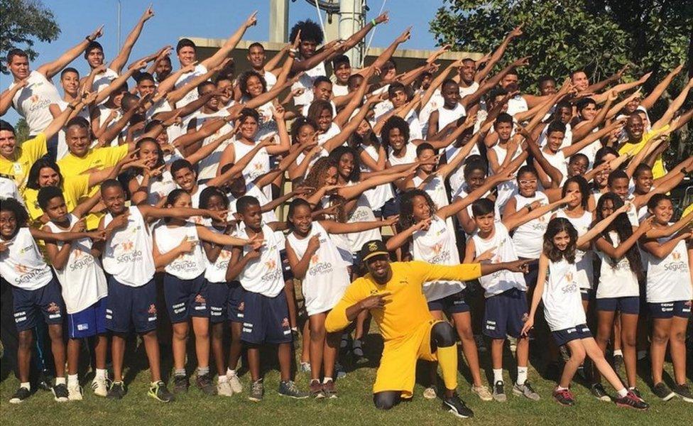 Jamaican athlete Usain Bolt with children in a Rio favela - 2 August 2016