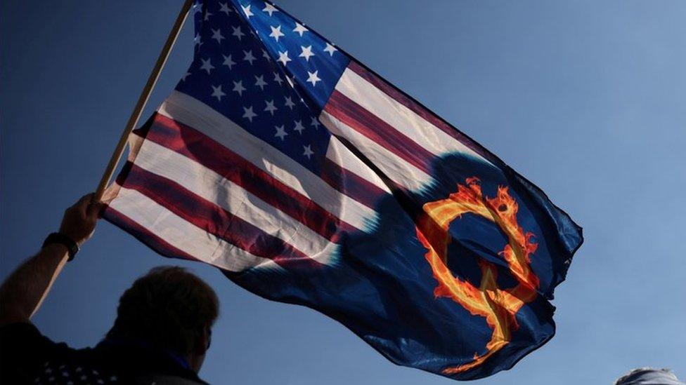 A supporter of President Donald Trump holds an U.S. flag with a reference to QAnon during a Trump 2020 Labor Day cruise rally in Oregon city, Oregon, U.S. September 7, 2020