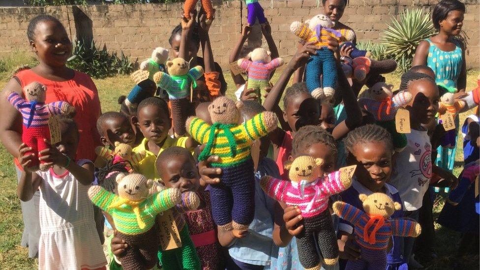 Children in Africa with knitted teddies