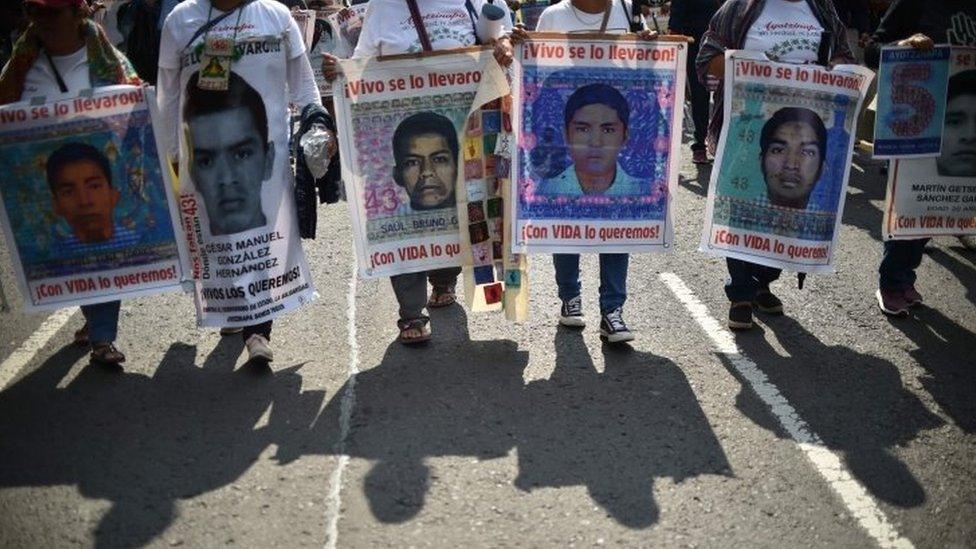 In this file photo taken on September 26, 2019 people protest in Mexico City to mark five years of the disappearance of the 43 students of the teaching training school in Ayotzinapa