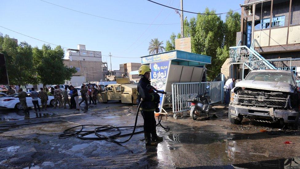 A firefighter hoses down a street after the suicide bomb attack