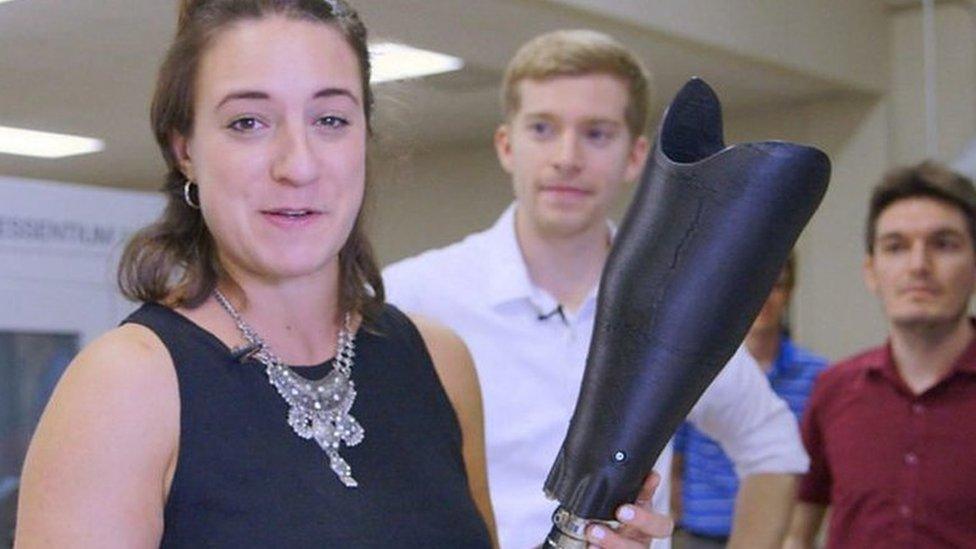 Kathleen holding up a 3D printed leg